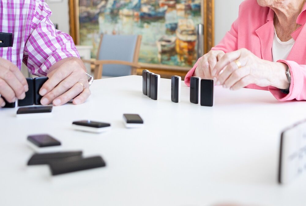 Varios usuarios de la residencia jugando al dominó
